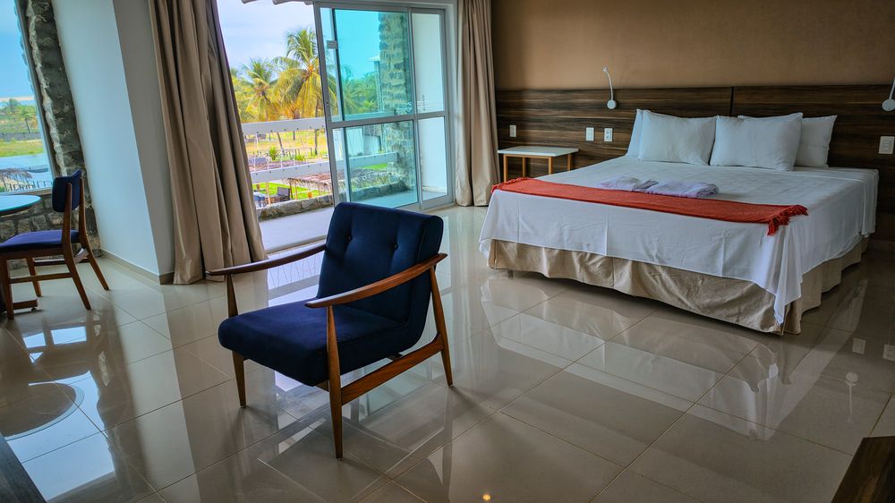 Interior do apartamento com poltrona e vista para o jardim
